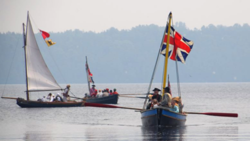 two boats crewed by men in historical costume