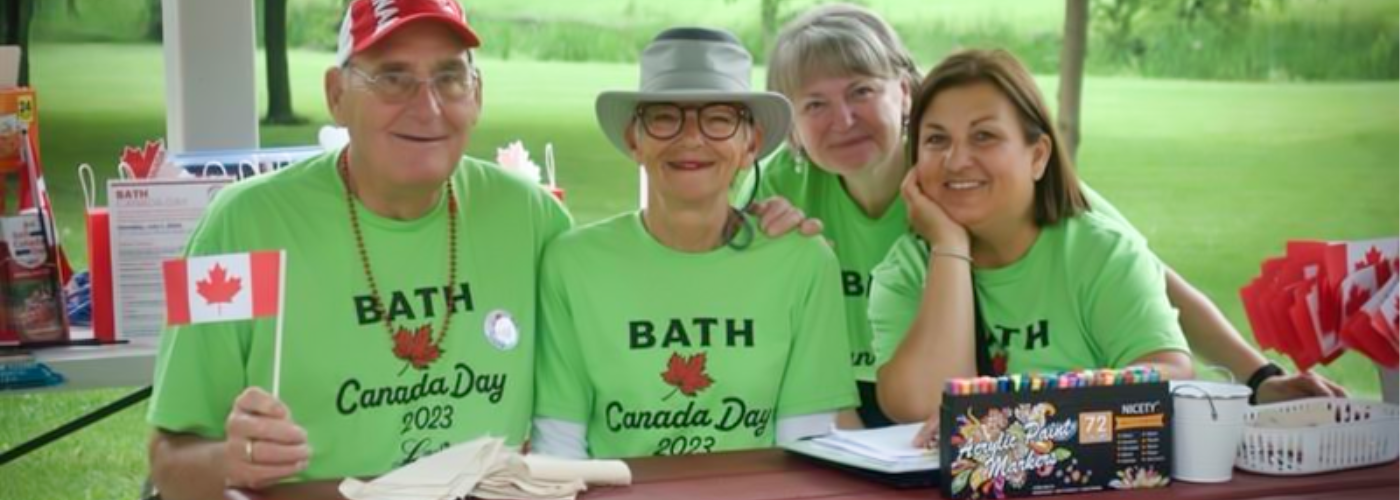 people sitting at a bench with green volunteer t-shirts