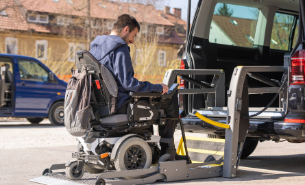 Man in wheelchair getting on ramp for accessible van