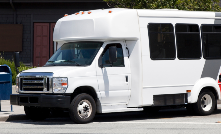 Small transit bus parked in front of building