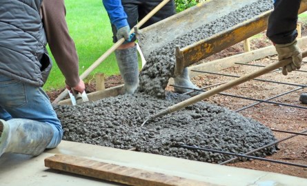 workers pouring concrete to form a driveway