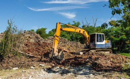 backhoe next to a large pile of sod