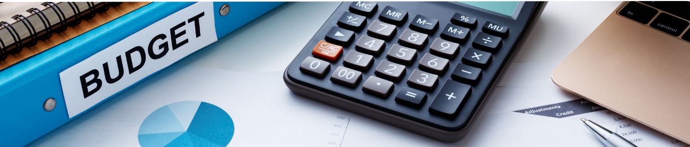 Desk with a binder, calculator and papers