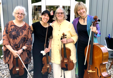 Four women holding violins and a cello
